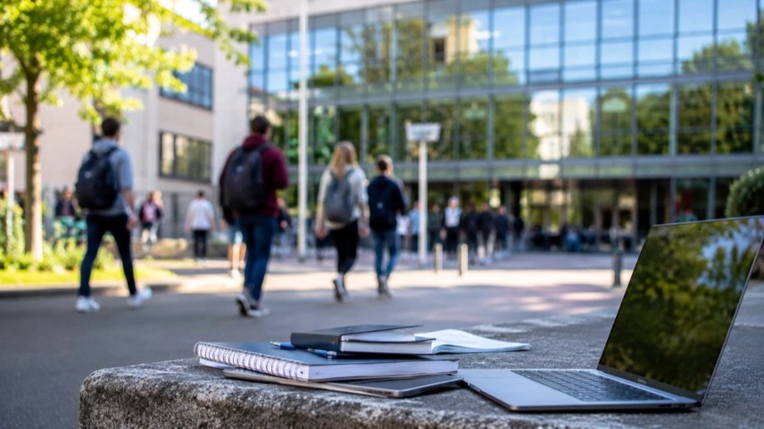 Studierende auf einem Universitätscampus mit Lernmaterialien und Laptop im Umfeld der BAföG-Reform und Studienfinanzierung