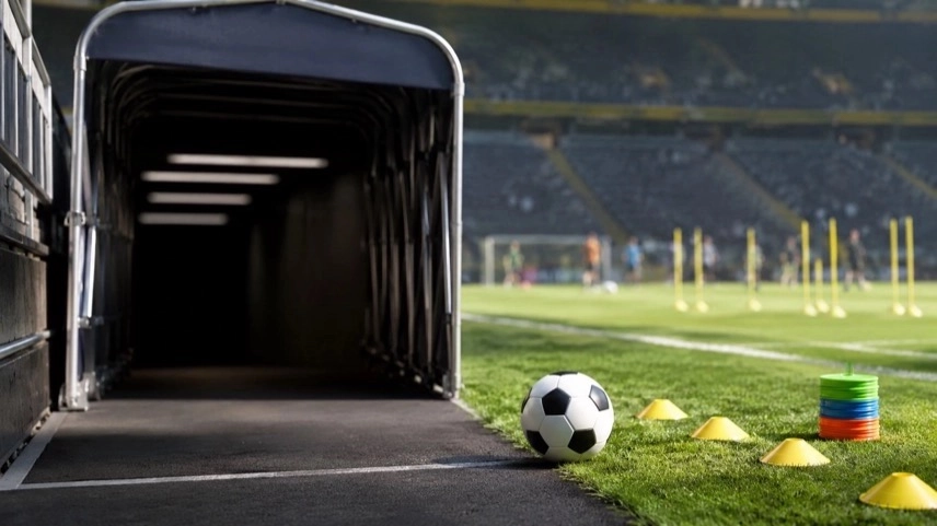 Leerer Spielertunnel in einem Fußballstadion mit Ball und Trainingsmarkierungen zum Thema Borussia Dortmund und Jadon Sancho