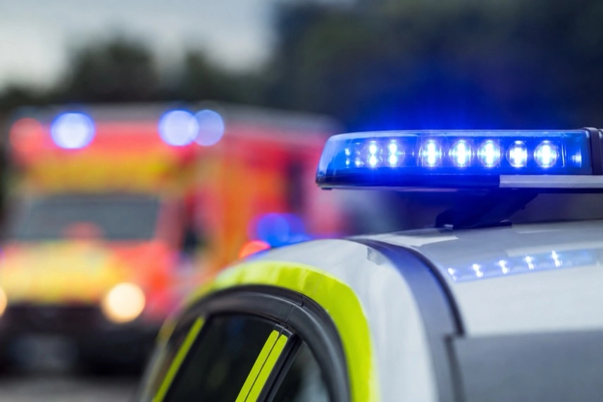 Neutrales Rettungsfahrzeug auf einer Landstraße vor unspezifischer ländlicher Umgebung