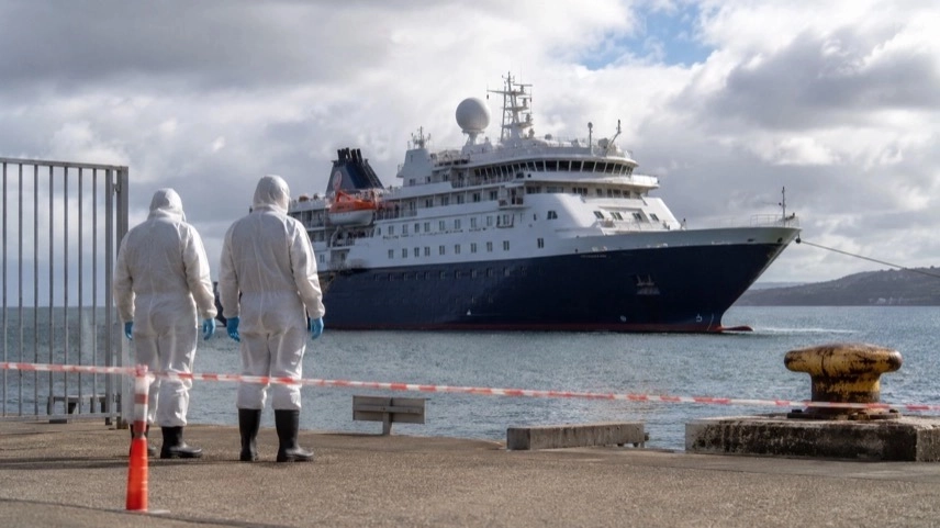 Expeditionskreuzfahrtschiff vor Küste mit medizinischem Sicherheitspersonal bei Hantavirus-Quarantäne und Evakuierung