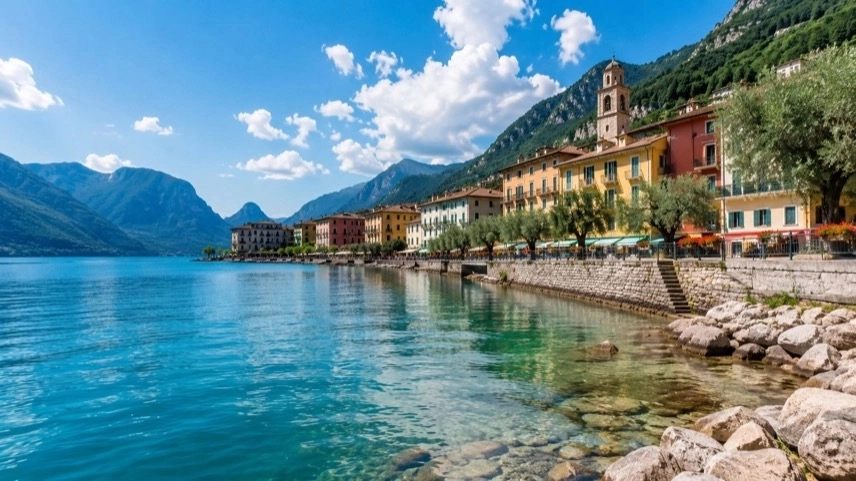 Uferpromenade von Limone sul Garda am Gardasee mit klarem Wasser, historischen Gebäuden und Berghängen