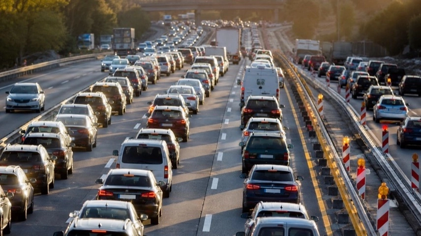 Dichter Pfingstverkehr mit langen Fahrzeugreihen auf deutscher Autobahn in Baustellenbereich bei hohem Reiseaufkommen