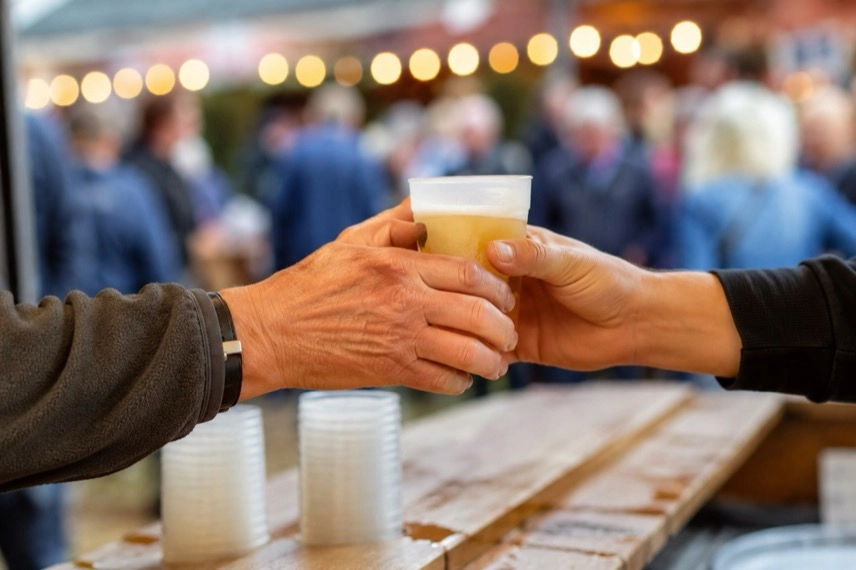 Weinglas, Weintrauben, schwarzer Zylinder und Messspindel auf einem Festtisch beim symbolisierten Oechsle-Fest.