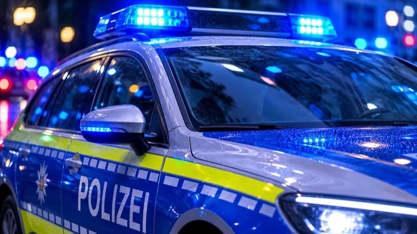 Abgesperrter Hauseingang bei nächtlichem Polizeieinsatz nach Messerangriff in Hamburg mit Blaulicht im Hintergrund