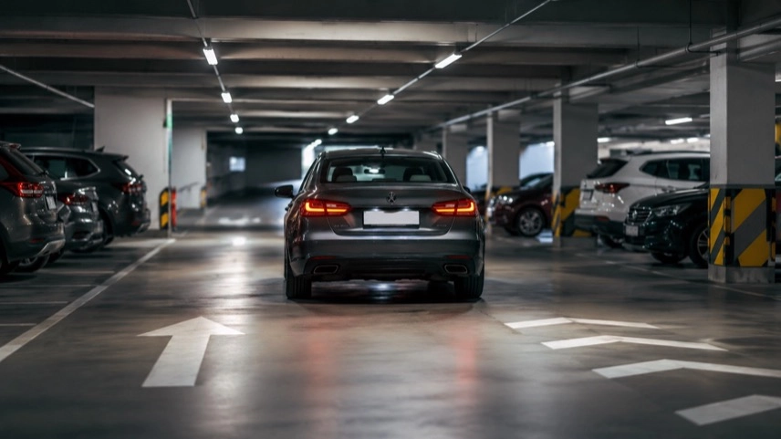 Auto auf einer Fahrspur in einem Parkhaus mit Verkehrszeichen und Markierungen zum Thema Trunkenheit am Steuer