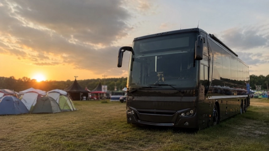 Tourbus auf einer Festivalwiese mit Campingbereich als Unterkunft beim Wacken Open Air 2026