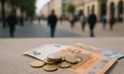 Symbolbild Witwenrente Kürzung ab Dezember 2025 – Euro-Münzen und 50-Euro-Schein als Darstellung der finanziellen Belastung durch Rentenzuschlag.