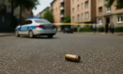 Foto einer nachgestellten Straßenszene in Ludwigshafen mit Patronenhülse, Blutspur und Polizeiauto im Hintergrund, genutzt für Newsartikel zu tödlichen Schüssen.