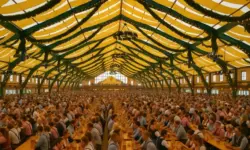 Symbolbild Oktoberfest Festzelt – Innenansicht mit langen Bänken, Menschen in Tracht und festlicher Dekoration, fotorealistische Nachstellung als illustrative Darstellung.