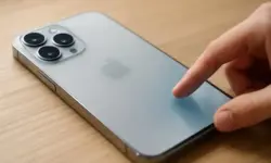 iPhone mit Liquid Glass Effekt auf Holzoberfläche, Symbolbild für Artikel über Deaktivierung und Einstellungen von iOS 26.