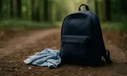 Symbolbild eines blauen Rucksacks mit Tüchern auf einem Waldweg, stellvertretend für die Suche nach einem vermissten elfjährigen Jungen im Ennepe-Ruhr-Kreis.