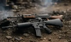 zwei zurückgelassene Sturmgewehre auf Schutt und Erde, als Darstellung der Gewalt- und Bandenkrise in Haiti.