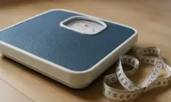 Abnehmen – analoge Personenwaage mit blauem Belag und Maßband auf Holzboden, Darstellung zum Thema japanische Atemtechnik.