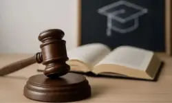 Richterhammer und Buch vor Schultafel – Darstellung zum Fall der falschen Lehrerin in Heidelberg mit Haftbefehl und Betrugsvorwürfen.