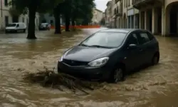 Überflutete Straße in Norditalien mit teilweise versunkenem Auto nach heftigen Unwettern und Überschwemmungen.