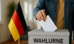 Wahlurne mit Stimmabgabe vor deutscher Flagge, stellvertretend für die Debatte um Jugendbeteiligung und Wahlalter 16 in Deutschland.