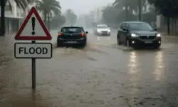 Symbolbild einer überfluteten Straße auf Ibiza mit Autos im Regen, aufgenommen in fotorealistischem Stil, zur Illustration der Unwetterlage.