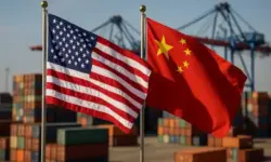 US- und China-Flaggen wehen vor gestapelten Containern in einem Hafen bei Tageslicht.