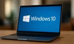 Moderner Laptop auf einem Holztisch mit blauem Windows-10-Hintergrund auf dem Bildschirm, hell ausgeleuchtet und scharf fokussiert.