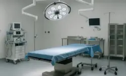 Leerer, moderner Operationssaal mit OP-Tisch, chirurgischen Instrumenten, Monitor und Beleuchtung, ohne Menschen, hell ausgeleuchtet.