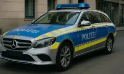 Deutsches Polizeiauto mit blauer und gelber Lackierung steht auf einer Stadtstraße bei Tageslicht.