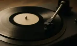 Nahaufnahme eines Plattenspielers mit aufgelegter Vinyl-Schallplatte und Tonarm bei natürlicher Beleuchtung.