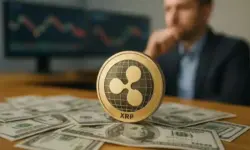 Goldene XRP-Münze auf US-Dollar-Scheinen mit unscharfem Hintergrund und Monitoren im Büro.