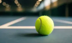 Tennisball auf einem Indoor-Hartplatz mit starker Tiefenschärfe und heller Beleuchtung.
