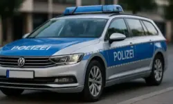 Ein deutsches Polizeiauto steht am Straßenrand einer Stadt, aufgenommen bei Tageslicht.