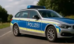 Zwei stark beschädigte Autos nach einem Frontalzusammenstoß auf einer Landstraße, umgeben von Trümmern und Herbstlandschaft.