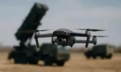 Fotorealistisches Symbolbild einer Drohne in der Luft mit unscharfen Militärfahrzeugen im Hintergrund, Nachstellung zum Thema Drohnen-Abschuss-Gesetz.