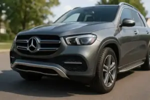 Silbergrauer Mercedes-SUV steht bei Tageslicht auf einer asphaltierten Straße mit Bäumen im Hintergrund.