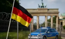 Migration Meeting München 2025 – Grenzzaun mit Stacheldraht und Polizeifahrzeug im Hintergrund, Darstellung für Migrationspolitik in Europa.