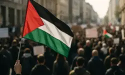 Symbolbild zu den pro-palästinensischen Protesten in Italien mit einer wehenden Flagge und unscharfer Menschenmenge im Hintergrund.