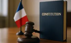 Regierungskrise in Frankreich mit Gavel, Verfassungsbuch und französischer Flagge im Hintergrund.