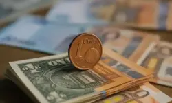 Merz’ Warnung vor sinkenden Löhnen – Nahaufnahme von Euro-Geldscheinen und Münze als Darstellung wirtschaftlicher Unsicherheit in Deutschland.