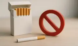 Eine offene Zigarettenschachtel mit mehreren Zigaretten, daneben ein rotes Verbotsschild auf einem hellen Holztisch.