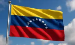 Die venezolanische Flagge mit gelben, blauen und roten Streifen weht im Wind vor einem leicht bewölkten Himmel.