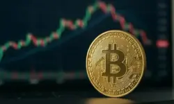 Goldene Bitcoin-Münze in Nahaufnahme vor einem unscharfen Hintergrund mit Börsencharts.