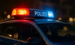 Deutscher Streifenwagen mit aktiviertem Blaulicht, fotografiert bei Nacht in Nahaufnahme.