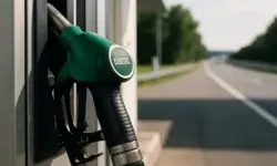 Grüne Diesel-Zapfpistole steckt in einer Tanksäule, im Hintergrund eine unscharfe Straße bei Tageslicht.