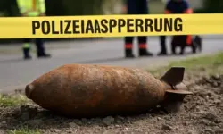 Absperrband im Vordergrund, dahinter unscharfe städtische Gebäude bei Tageslicht.