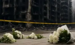 Gelbes Absperrband im Vordergrund, dahinter ein unscharfes modernes Hochhaus bei Tageslicht.