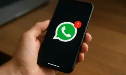 Eine Hand hält ein Smartphone mit dem WhatsApp-Logo und einer Benachrichtigung über eine neue Nachricht.