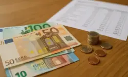 Ein Schreibtisch mit Euro-Münzen, Geldscheinen und Dokumenten, weich ausgeleuchtet und fotorealistisch aufgenommen.