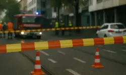 Abgesperrte innerstädtische Straße mit Absperrband, Verkehrskegeln und einem Feuerwehrfahrzeug im Hintergrund.