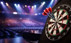 Dartboard mit gesteckten Pfeilen in einer beleuchteten Turnierhalle während der Darts-WM im Alexandra Palace