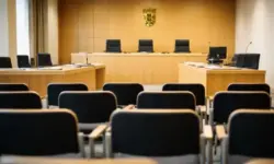 Leerer Gerichtssaal mit Richterbank und Zeugenstand während eines Strafprozesses am Landgericht, sachliche Innenaufnahme ohne Personen.