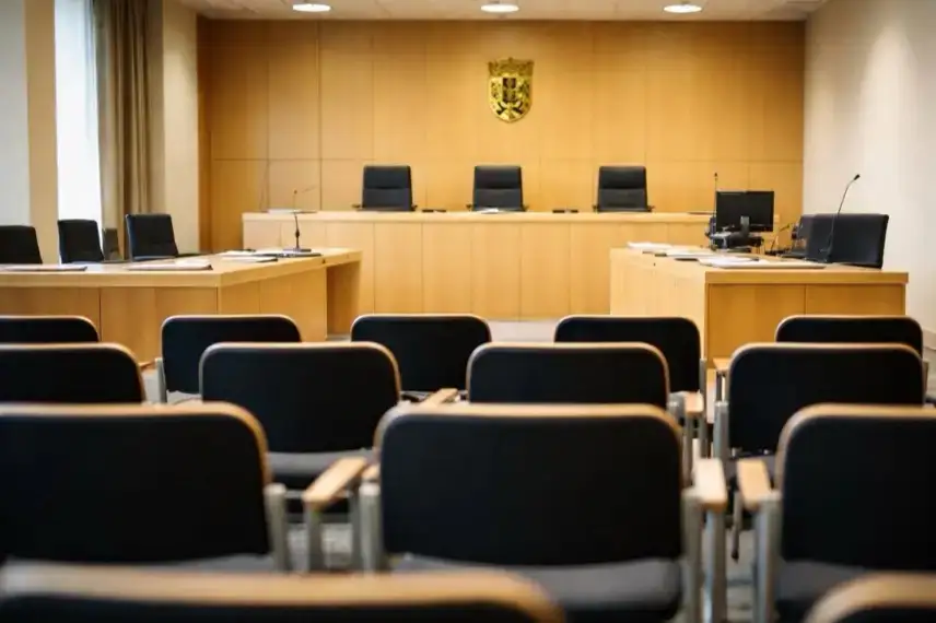 Leerer Gerichtssaal mit Richterbank und Zeugenstand während eines Strafprozesses am Landgericht, sachliche Innenaufnahme ohne Personen.