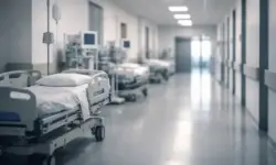 Leerer Krankenhausflur mit Betten und medizinischen Geräten bei gedämpftem Licht während der aktuellen Grippesaison mit steigenden Fallzahlen